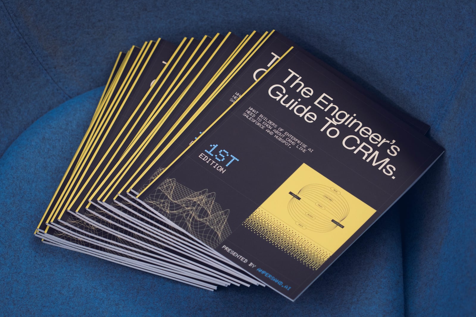 Printed copies of The Engineer’s Guide to CRMs fanned out on a blue chair
